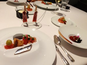 "Tomato" 2013: Clock-wise from top left: Tomato flash with herbaceous touches; Crispy sponge with tomato sirloin and duck; Roasted tomato into Bourbon barrels; Mediterranean rock with tomatoes of every kind and sardines