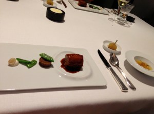 Goat kid with Majorcan sausage and honey, potato and licorice spiral, pods, and elderflower; "Minestrone" soup with pasta and spicy sausage; Medlar filled with tomato, anise, and long pepper.